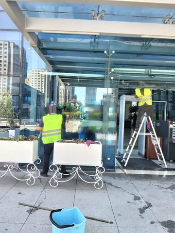 Reflektif yelekli ekip, plaza giriş cephesinde