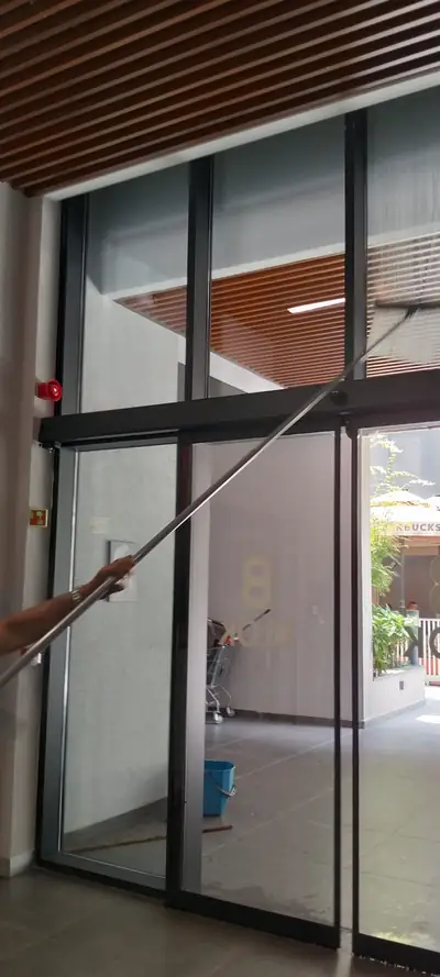 Bina giriş camı teleskopik aparatla temizlenirken