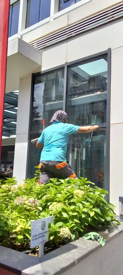 Personel çekpasla plaza penceresini temizlerken
